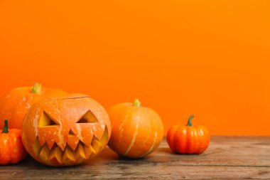 Cadılar Bayramı kutlaması için balkabakları ahşap masada, yakın plan.