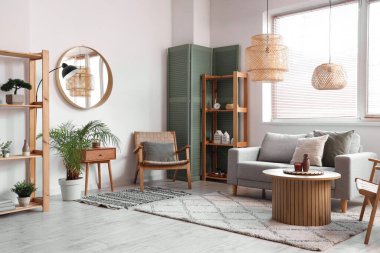 Rahat kanepesi, masası ve katlanır perdesi olan modern oturma odasının içinde.