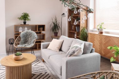 Oturma odasında rahat bir koltuk, kanepe ve masa.