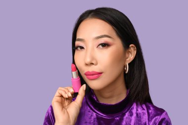 Leylak arkaplanda ruj izi olan güzel Asyalı kadın.