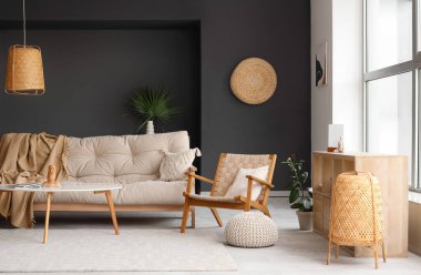 Oturma odasında ekose ve yastıklı rahat bir kanepe, koltuk, puf ve kahve masası.