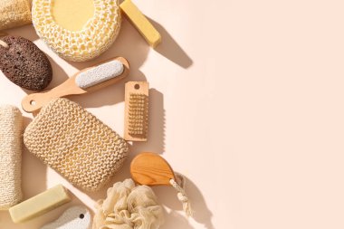 Farklı banyo süngerleri, masaj fırçaları ve renk arkaplanlı sabun içeren kompozisyon