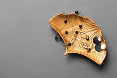 Gri arka planda güzel mücevherleri olan altın tepsi