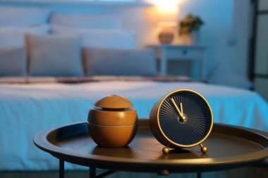 Geceleri yatak odasındaki masasında hava nemlendiricisi olan çalar saat, kapatma.