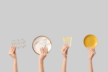 Plakalı kadın elleri, yumurta tutacağı ve beyaz arka planda cam.