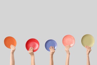 Beyaz arka planda farklı plakalı kadın elleri