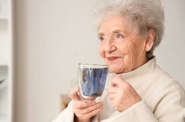 Evde elinde bir bardak kelebek çiçeği çayıyla son sınıf öğrencisi.