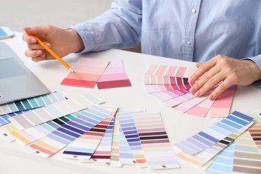 Oturma odasında pembe renk paletleri olan kadın iç mimar.