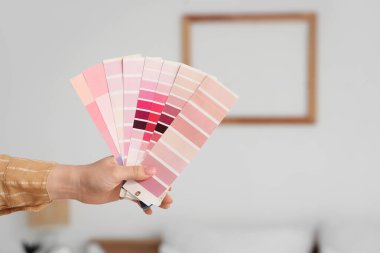 Yatak odasında pembe renk paletleri olan bir iç mimar.