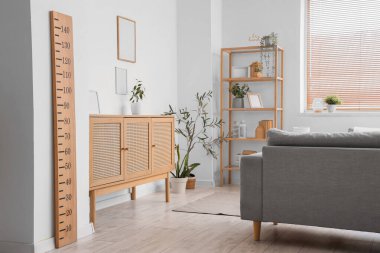 Modern oturma odasının içinde kanepe, raf ünitesi, tuvalet ve ahşap stadyum var.