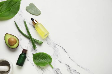 Kozmetik ürünleri şişeleri, guasha aracı ve mermer zemin malzemeleri bileşimi