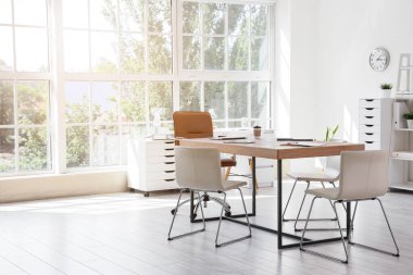 Masası ve penceresi olan konferans salonunun içi