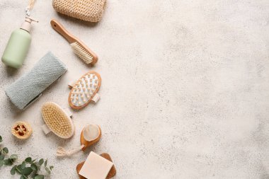 Beyaz grunge arka planda masaj vücut fırçaları, havlu ve bir şişe kozmetik ürünü ile kompozisyon