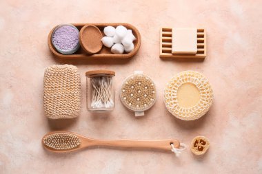 Tepsi, masaj vücut fırçası, banyo süngeri ve pembe grunge arka planda pamuk çubukları olan kavanoz, yakın plan.