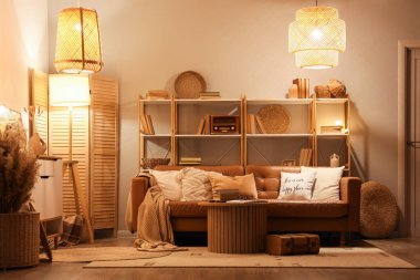 Kitaplık, kanepe ve gece lambasıyla oturma odasının içinde.