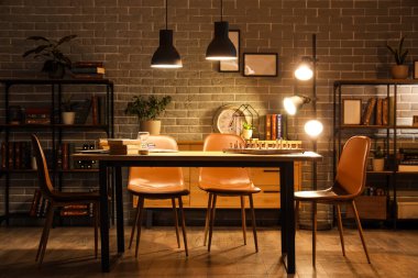 Geceleri kitap rafları, masa lambaları ve parlayan lambalarla dolu karanlık bir oda.