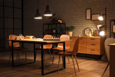 Geceleri kitap rafı, masa ve parlayan lambaları olan karanlık bir oda.