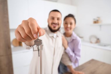 Mutfaktaki yeni dairesinden anahtarı olan genç çift, yakın plan.