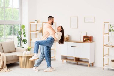 Eski radyo alıcısı olan genç bir çift evde dans ediyor.