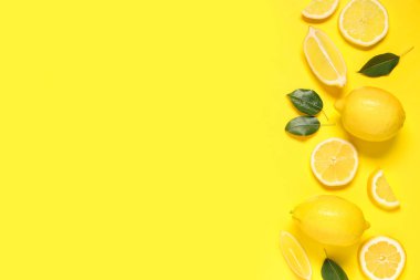 Taze olgun limonlar ve sarı arka planda yapraklar