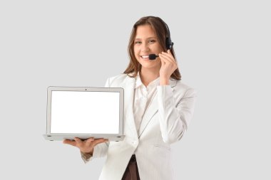 Işık arka planında boş dizüstü bilgisayarı olan kadın teknik destek ajanı