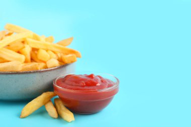 Lezzetli patates kızartması ve mavi arka planda ketçap.