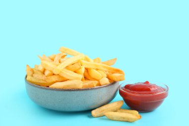 Lezzetli patates kızartması ve mavi arka planda ketçap.