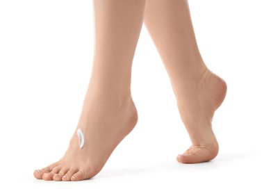 Beyaz arka planda izole edilmiş taze pedikür ve kremi olan genç bir kadının ayakları.