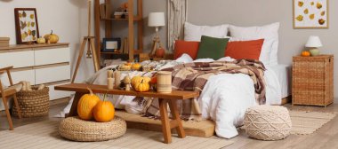 Sonbahar süslemeleri ve mumları olan şık bir yatak odası.