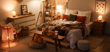 Sonbahar süslemeleri ve akşamları mumları olan şık bir yatak odası.