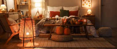 Sonbahar süslemeleri ve akşamları mumları olan şık bir yatak odası.