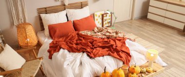 Sonbahar süslemeleri ve büyük yataklı şık bir yatak odası.