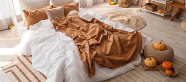 Yatak odasının içinde raf ünitesi, otlar ve balkabakları var.