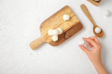 Beyaz masada nefis hindistan cevizi şekeri alan bir kadın.