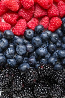 Arka plan olarak taze ahududu, böğürtlen ve yaban mersini, yakın plan