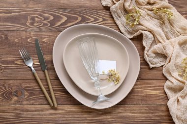 Kahverengi ahşap arka planda kartı olan modern masa ayarları