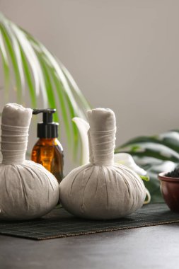 Masanın üzerinde gri duvara karşı kaplıca torbaları.