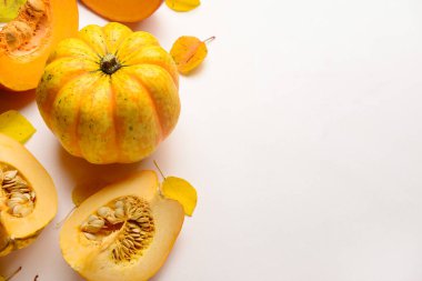 Beyaz arka planda taze balkabakları ve sonbahar yaprakları