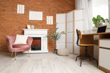 Tabloları, şöminesi ve işyeri olan şık bir oda.