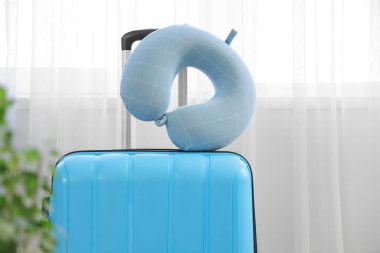 Bavuldaki boyun yastığı ışık perdesinin yanında. Seyahat kavramı