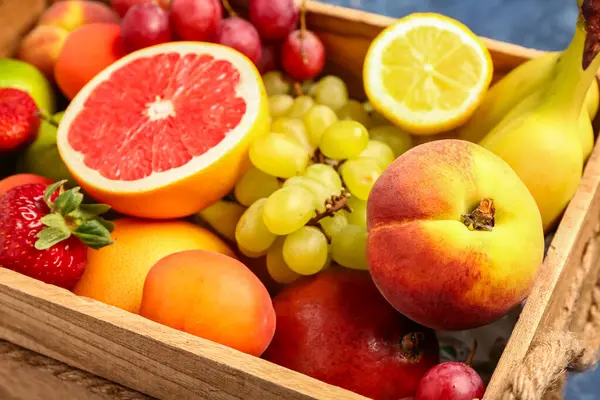 Farklı taze meyvelerle ahşap kutu, yakın plan.