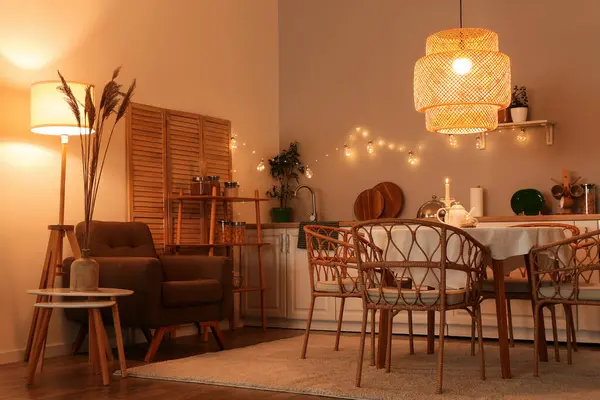 Parlayan lambalar, masa, beyaz tezgah ve sandalyeli modern mutfak.