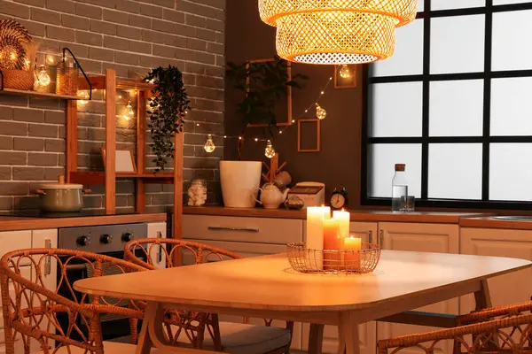 Parlayan lambaları, beyaz tezgahları, akşamları sandalyeleri ve masası olan şık bir mutfak.