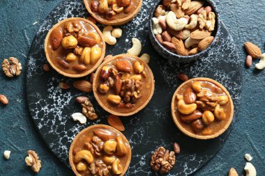 Fındıklı ve karamel soslu lezzetli tartlar grunge mavisi arka planda