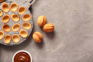 Lezzetli ceviz şekilli kurabiyeler ve grunge arka planında haşlanmış süt ile pişirme biçimi