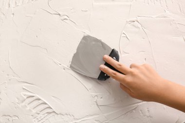 Bıçaklı işçi beyaz macunu yakın plan koyuyor.