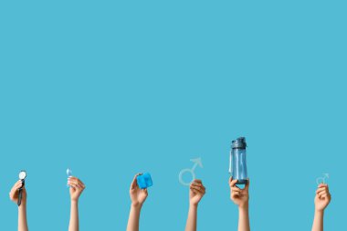 Mavi kurdeleli kadın eller ve renkli arka planda erkek sembolleri. Prostat Kanseri Farkındalığı Ayı