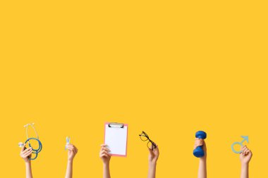 Mavi kurdeleli kadın eller, erkek sembolü ve sarı arka planda pano. Prostat Kanseri Farkındalığı Ayı