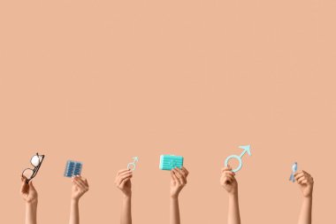 Erkek sembollü kadın elleri, mavi kurdele ve bej arka planda haplar. Prostat Kanseri Farkındalığı Ayı