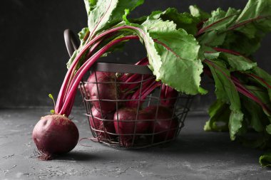 Siyah arka planda taze pancar kökleri olan sepet.